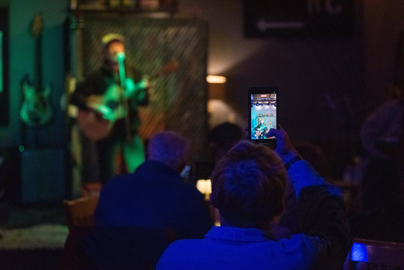 A guest filming a set at Open Mic Night