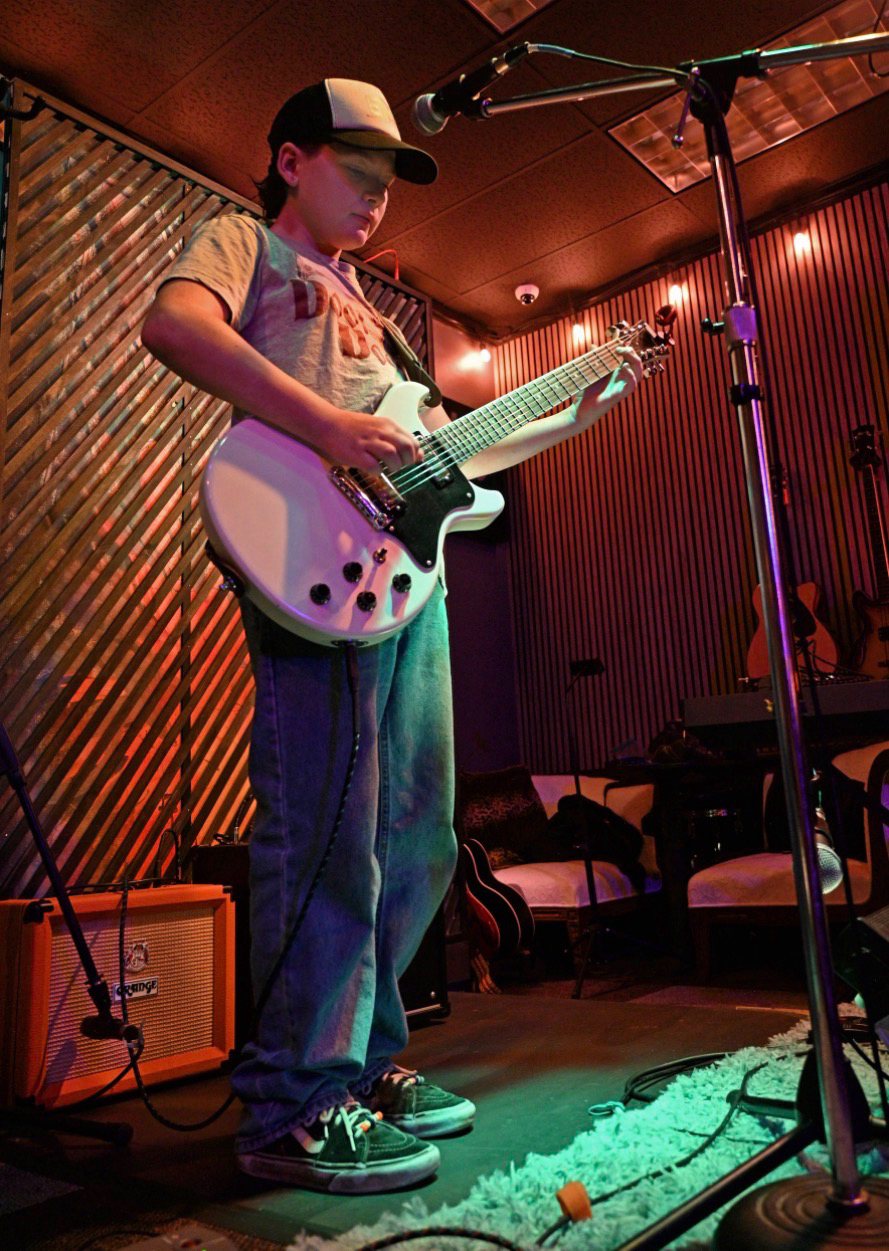 A young player on stage at Open Mic Night